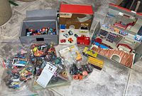 Overall collection of miniature toy cars, play sets, and carrying cases arranged on floor surface
