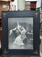 Full view of the framed black and white print depicting a man and lady, including the frame with gold accents