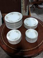 View of all plate and bowl stacks on a wooden table showing full set composition.