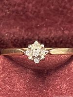 Front view showing flower‐shaped diamond cluster on gold band