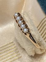 Top view showing row of five pearls on gold band