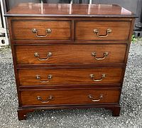 Front view showing two small top drawers and three full-width drawers with brass bail handles
