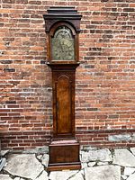Full front view of entire clock against brick wall