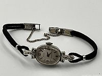 Watch face angled view showing diamond-set lugs and braided cord strap