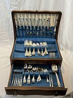 Full set displayed in open hinged wooden box showing cutlery in top and drawer compartments