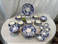 Full spread of all dinnerware pieces on table with reference apple