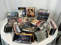 Wide overhead view of approximately 79 DVDs spread on a table, showing a diverse collection of classic and cult films including The Silence of the Lambs and The Godfather.