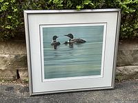 Full front view of framed print leaning against hedge