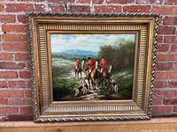 Frontal view of framed oil painting showing hunters on horseback with hounds in landscape