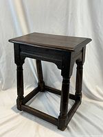 Angled front view showing rectangular top, carved apron and turned legs