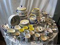 Overview of over 90 pieces with various plates, bowls, cups, mugs, tureens