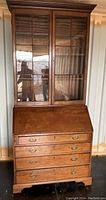 Front view of walnut secretary desk with bookcase doors closed