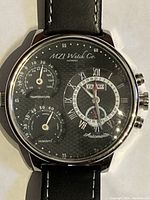 Close-up frontal image of MZI Watch Co men's automatic watch showing dial with temperature gauge, humidity gauge, and calendar subdials.