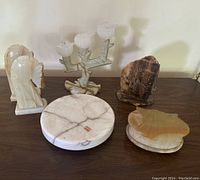 Lot showing all alabaster decor pieces: clock, bookends, candle holder, shell box, and marble base