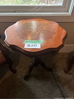 View of the scalloped edge wooden side table top showing floral inlay and geometric wood pattern with measuring note (21.5 x 23 H)