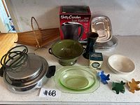Photo of the entire lot showing various kitchen items including Betty Crocker kettle box, colander, glass dish, and other accessories.