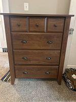 Front view of the wooden highboy dresser showing drawer configuration and metal hardware