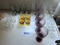 Overview of entire glassware collection showing grouped sets of glasses of various colors and styles.