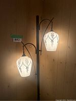 Lamp illuminated showing two glass shades and pattern detail