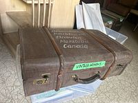 Wooden vintage trunk from a top view, showing the label 'Vintage Womens' and travel labeling.