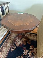 Top view showing the detailed inlaid wood design and scalloped edges of the table.