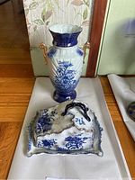 Full view of the blue and white decorative ceramic vase and matching tureen with lid showing floral and ornamental details.