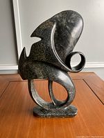 Front side of the abstract soapstone carving showing smooth curves, pointed edges, and a looped form with a glossy finish.