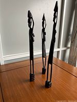 Full view of the three ebony sculptures showing slender shape and smooth dark finish.