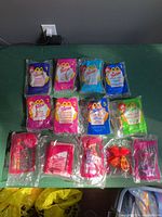 Photo showing all 15 McDonald's Barbie Happy Meal Toys sealed in their original packaging with various colors and numbers.