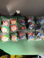 All Mulan Happy Meal Toys from both sets arranged on a surface, showing sealed packaging and numbering.