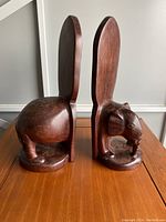 Side view of two carved elephant mahogany bookends showing detailed head and base height