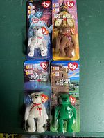 Set of four TY Beanie Bears in original packaging, featuring Glory, Britannia, Maple, and Erin bears for the Ronald McDonald House collection.