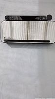 Top-down view of FoodSaver vacuum sealer showing stainless steel front and black control panel with buttons and dial.