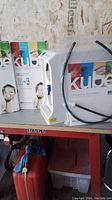 Kube water filtration system main unit with product boxes in background, showing branding and tubing.