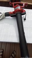 Top view of red Toro electric handheld leaf blower showing blower tube and handles.