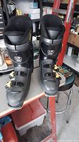 Front view of left and right Mens Munari ME 200 ski boots showing four buckles, size 11, and ski walk adjustment on cuff.