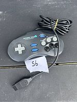 A single black Game Pad 6 wired game controller for Sega, showing buttons and connector cable coiled.