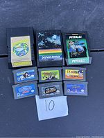 Photo showing 3 Atari 2600 game cartridges and 6 Game Boy game cartridges laid out on a dark surface with a paper numbered 10.