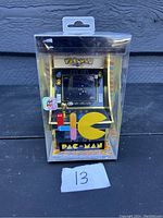 Pac-Man Micro Arcade handheld game in original packaging against black background with seller number 13