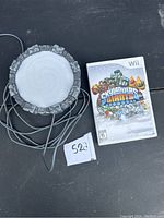 Skylanders Giants game case for Nintendo Wii next to the Portal of Power accessory with cable on a dark surface.
