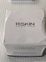 Front view of white box with 111SKIN logo and product name 'Rebalancing Night Cream 50 ml / 1.7 fl oz'. Box shows some wear and creases.