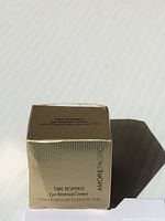 Gold-toned box of Amore Pacific Time Response Eye Renewal Creme, front and top views showing product name and brand.