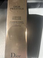 Photo of the front of the gold-colored box showing Dior Prestige La Mousse Micellaire Exceptional Gentle Cleansing Foam branding.