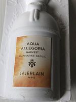 Close-up of label on the white matte bottle showing Aqua Allegoria Harvest Mandarine Basilic Guerlain Paris.
