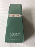 Front view of the green box showing the La Mer logo and product name 'The Resurfacing Treatment La Lotion Exfoliante' with 3.4 fl oz (100 ml) volume.