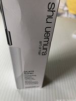 Photo of the white packaging box showing Shu Uemura branding and product name Izumi Tonic thickening serum for fragile hair, 90ml.