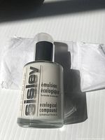 Front view of a new sealed Sisley ecological compound skincare bottle, showing the brand name, product name, and volume 60 ml.