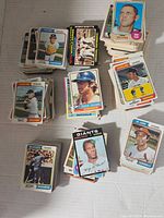 A pile of vintage baseball cards from various teams and players laid out on a flat surface