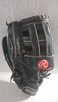 Side view showing black leather glove with Rawlings logo and 'Pad Lock' wrist strap.