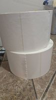 Two stacked rolls of white labels measuring 4x6 inches showing label separation lines.